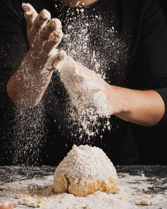 Farina lavorata a mano durante una preparazione artigianale